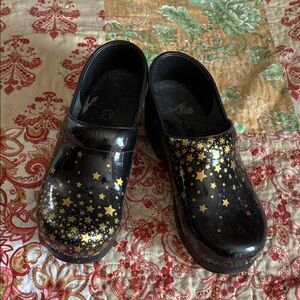 Dansko Black Patent Leather Clogs with Gold Star Print
